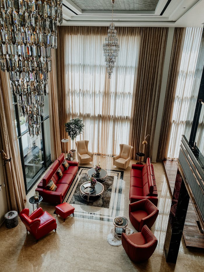 A lavish modern living area featuring chandeliers, luxurious seating, and elegant decor.