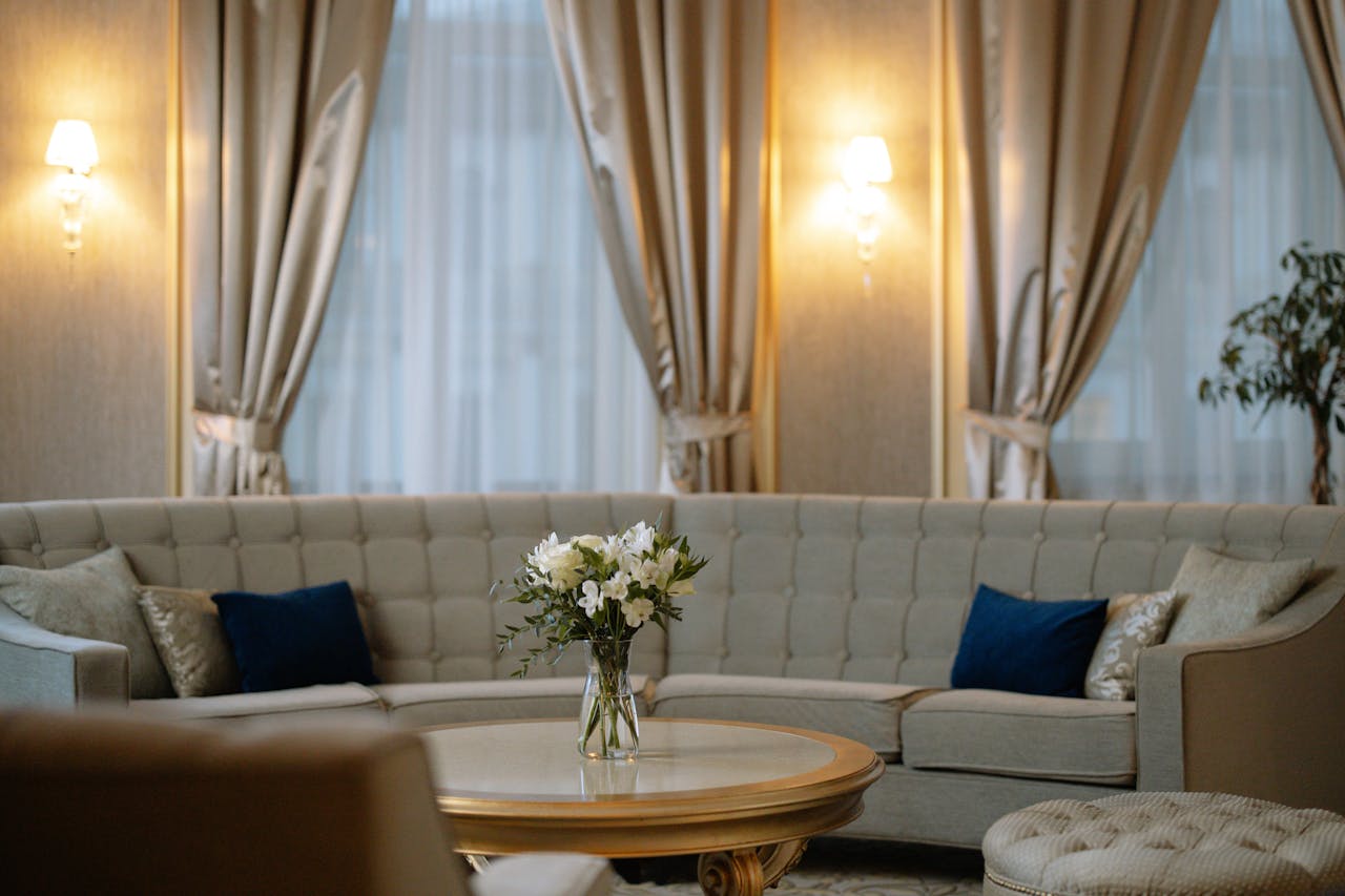 services-01 Luxurious lounge area featuring a plush sofa, chic curtains, and soft lighting.